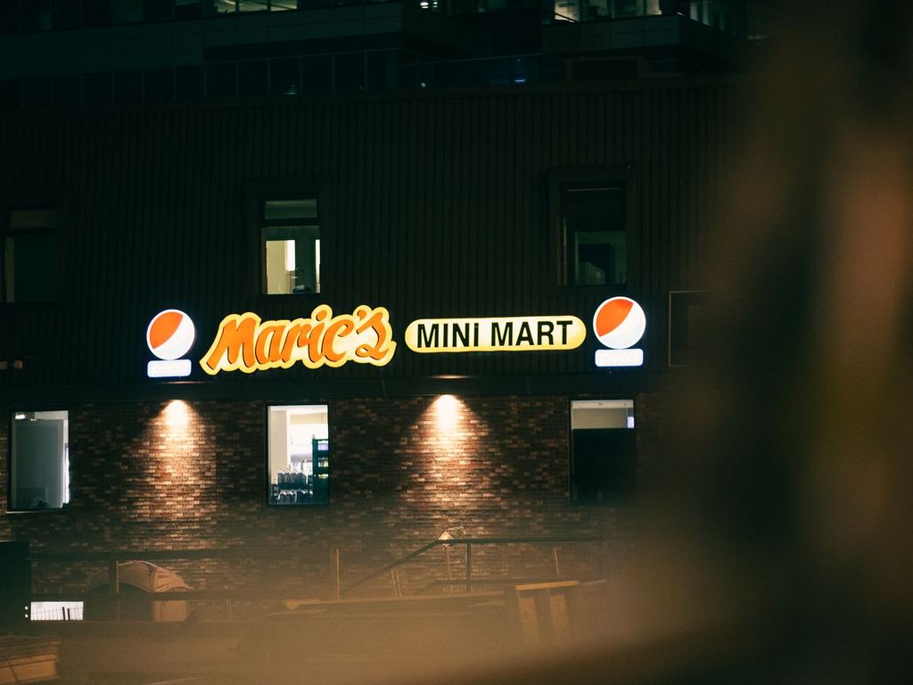Illuminated storefront sign on a commercial building at night