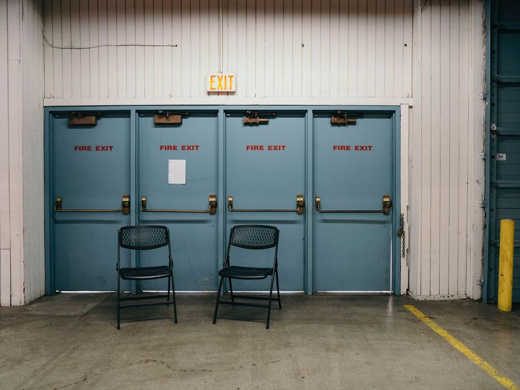 Row of blue fire exit doors inside a commercial warehouse