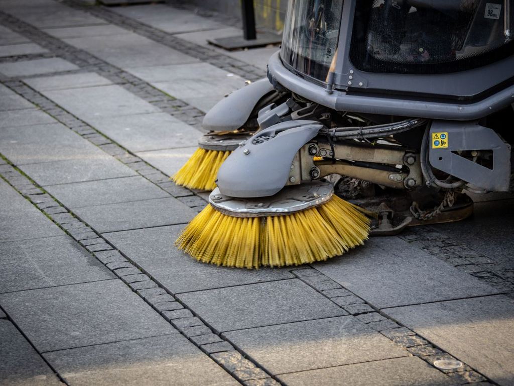 Close-up of a street sweeper’s brushes on pavement