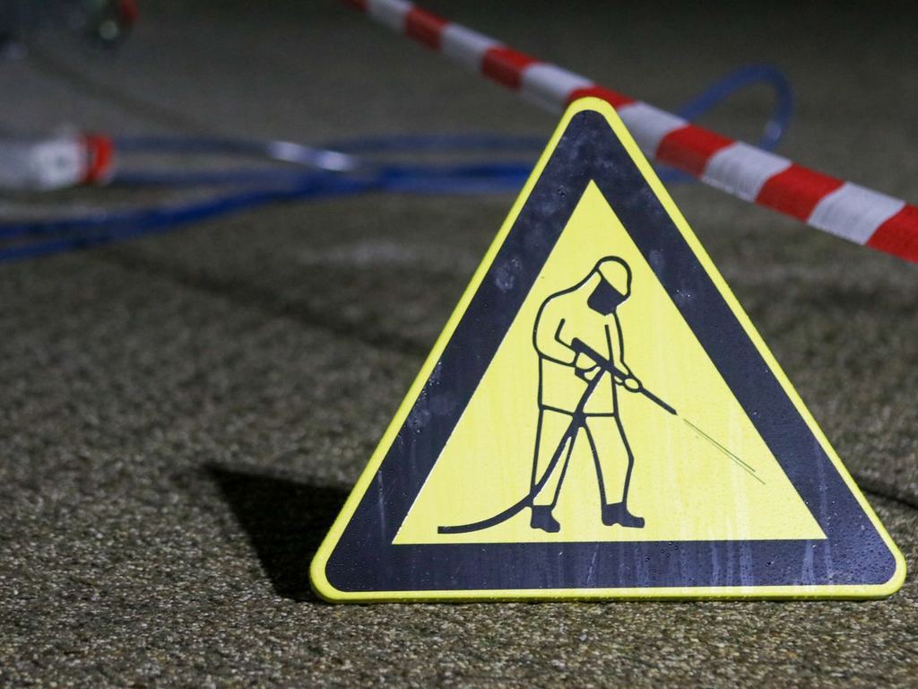 Pressure washing safety sign at an outdoor work area